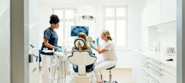 Zahnärztin erklärt Patientin die notwendige Zahnvorsorge.