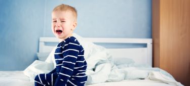 Kleinkind kann nicht schlafen und weint im Bett