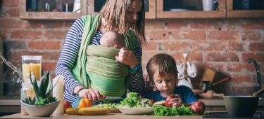 Kleinkind hilft junger Frau beim Kochen