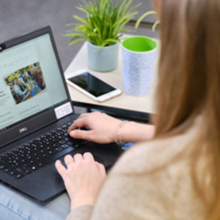 Auszubildende sucht nach Stellenanzeigen auf dem Laptop.
