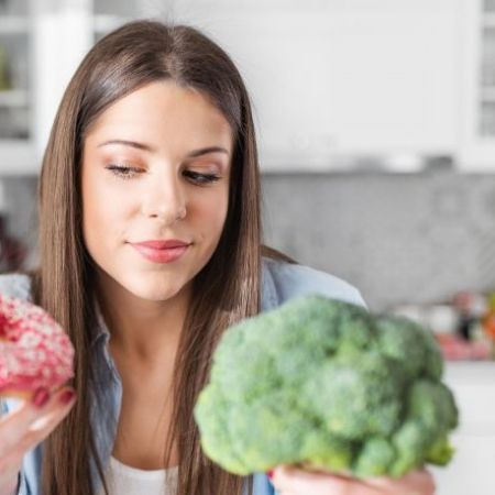 Mädchen zwischen Brokkoli und Fastfood.