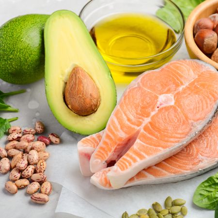 Es werden Lebensmittel wie Nüsse, Öl, Avocado und Lachs dargestellt.