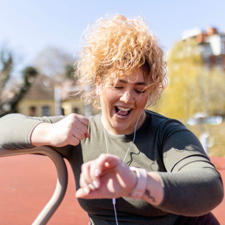 Eine übergewichtige Frau macht draußen Sport.