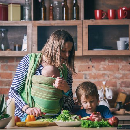 Kleinkind hilft junger Frau beim Kochen