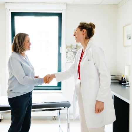 Eine Ärztin spricht vertrauensvoll mit einer Patientin.