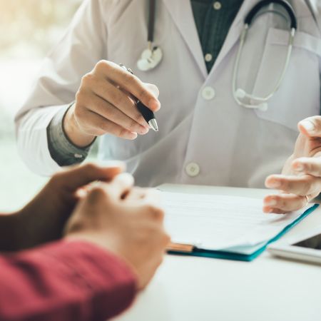 Ein Arzt berät einen Patienten in seiner Praxis.